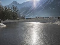 a black snow covered road in the mountains in the snow, as if for driving down a mountain