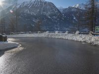 a black snow covered road in the mountains in the snow, as if for driving down a mountain