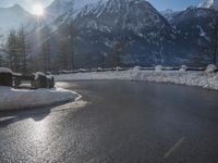 a black snow covered road in the mountains in the snow, as if for driving down a mountain