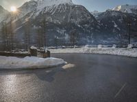 a black snow covered road in the mountains in the snow, as if for driving down a mountain