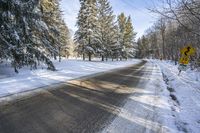 the sign reads turn right at the end of an empty road during wintertime in the canadian forest