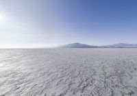 large expanse with clear water on it surrounded by snow covered hills and mountains in the background