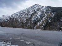 there is snow on the mountain side of the road to give a pleasant view of this mountainous area