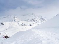 a group of skiers riding down the slopes of snowy mountains in front of snow capped mountains