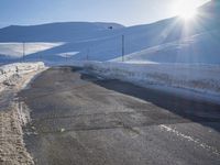 a ski slope is in the winter as the sun shines in the sky above