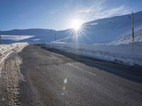 a ski slope is in the winter as the sun shines in the sky above