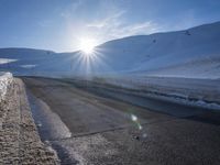 a ski slope is in the winter as the sun shines in the sky above