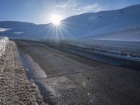 a ski slope is in the winter as the sun shines in the sky above