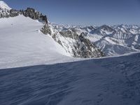 there is snow on the ground in the mountains near a ski slope and skiers