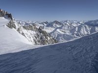 there is snow on the ground in the mountains near a ski slope and skiers