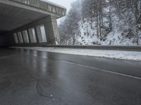 a motorcycle is parked by a tunnel near some snow covered trees outside of the tunnel