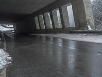 a motorcycle is parked by a tunnel near some snow covered trees outside of the tunnel