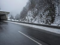 a motorcycle is parked by a tunnel near some snow covered trees outside of the tunnel