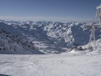 the mountains are covered in snow with a skier coming down a steep mountain side to the bottom