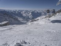 the mountains are covered in snow with a skier coming down a steep mountain side to the bottom