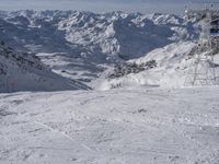 the mountains are covered in snow with a skier coming down a steep mountain side to the bottom