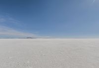 snow covered field with blue sky in the distance of the view is empty and full of snow