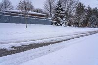 a view of some buildings and road after a snowfall on the other side of the street