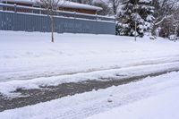 a view of some buildings and road after a snowfall on the other side of the street