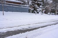 a view of some buildings and road after a snowfall on the other side of the street