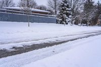 a view of some buildings and road after a snowfall on the other side of the street