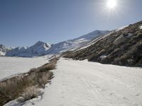 a person riding skis down a snow covered slope in the mountains with a view