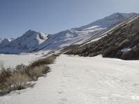 a person riding skis down a snow covered slope in the mountains with a view