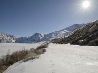 a person riding skis down a snow covered slope in the mountains with a view