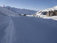 the slope is full of ski tracks and snow in this photo, with mountains behind