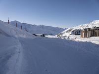 the slope is full of ski tracks and snow in this photo, with mountains behind