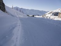 the slope is full of ski tracks and snow in this photo, with mountains behind