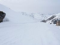 a man is snowboarding down the snowy hill near his house at a remote ski resort