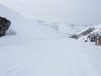 a man is snowboarding down the snowy hill near his house at a remote ski resort