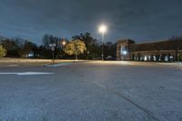 a empty parking lot with a car parked under a street light next to it at night