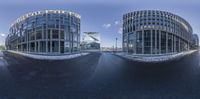 a street and some buildings and snow and blue sky and clouds behind them to depict a panorama