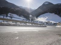 a person is riding their bike down the snow covered road of a mountain village in the winter