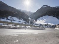 a person is riding their bike down the snow covered road of a mountain village in the winter