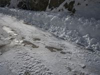 this is a snow road with some tire prints in the snow of the country side