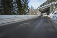 this is a photograph of a winter road passing by with trees in the background that seems to be very blurry