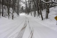 a road filled with snow and a yellow sign with an arrow pointing up to the road