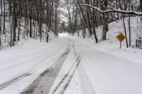 a road filled with snow and a yellow sign with an arrow pointing up to the road