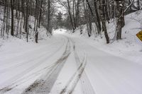 a road filled with snow and a yellow sign with an arrow pointing up to the road