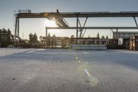 a road under an overpass with snow on the ground and buildings below and in the background