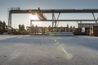 a road under an overpass with snow on the ground and buildings below and in the background