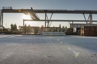 a road under an overpass with snow on the ground and buildings below and in the background