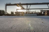 a road under an overpass with snow on the ground and buildings below and in the background