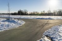 a picture of the snow on the road is clear and there is a white building in the distance