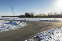 a picture of the snow on the road is clear and there is a white building in the distance