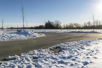 a picture of the snow on the road is clear and there is a white building in the distance