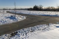 a picture of the snow on the road is clear and there is a white building in the distance